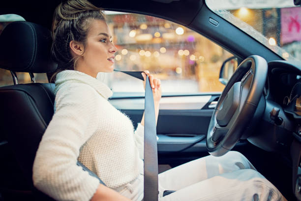 Young girl is fastening her seat belt in a rainy day